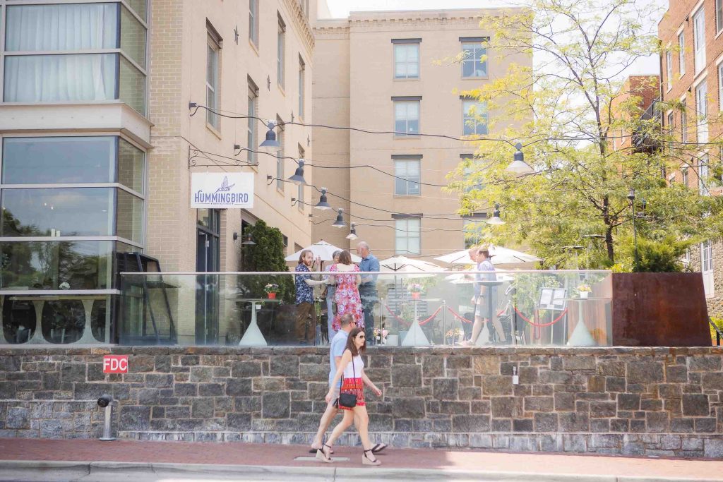 A woman is skateboarding in front of the Hummingbird Bar & Kitchen in Alexandria, Virginia.