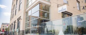 A glass facade building with a glass door located in Alexandria, Virginia for Hummingbird Bar & Kitchen.