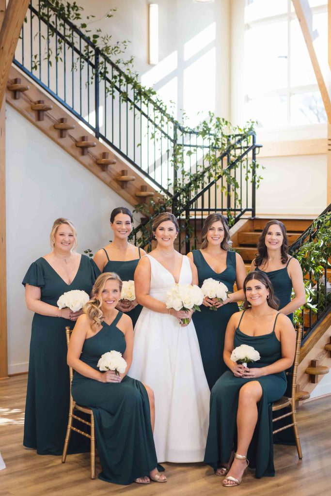 A wedding party poses in front of a staircase.