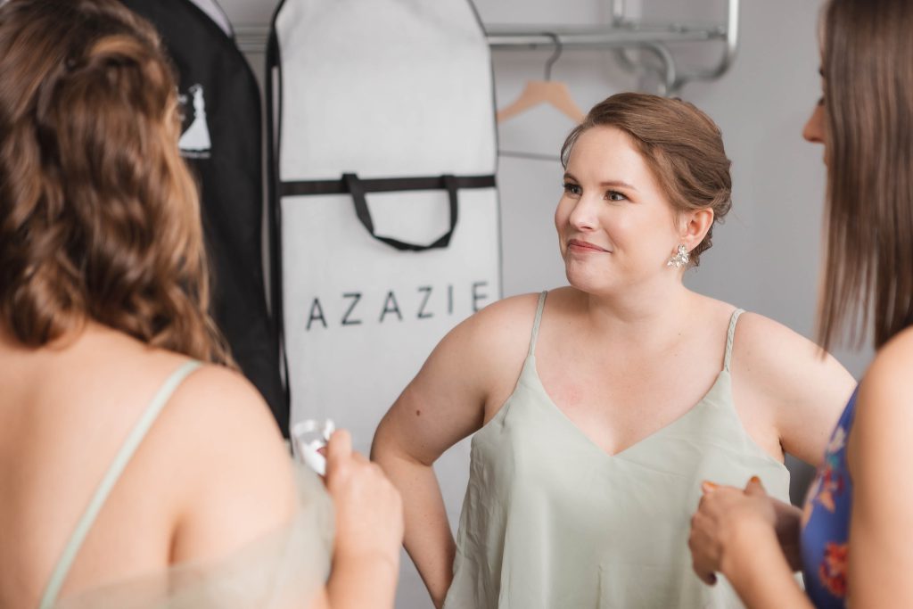 Bridesmaids candidly chatting during wedding preparation.
