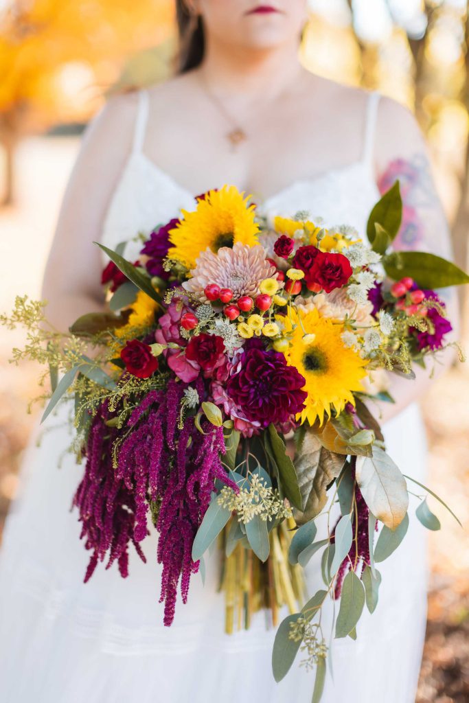 A wedding bride holding a bouquet of sunflowers.
