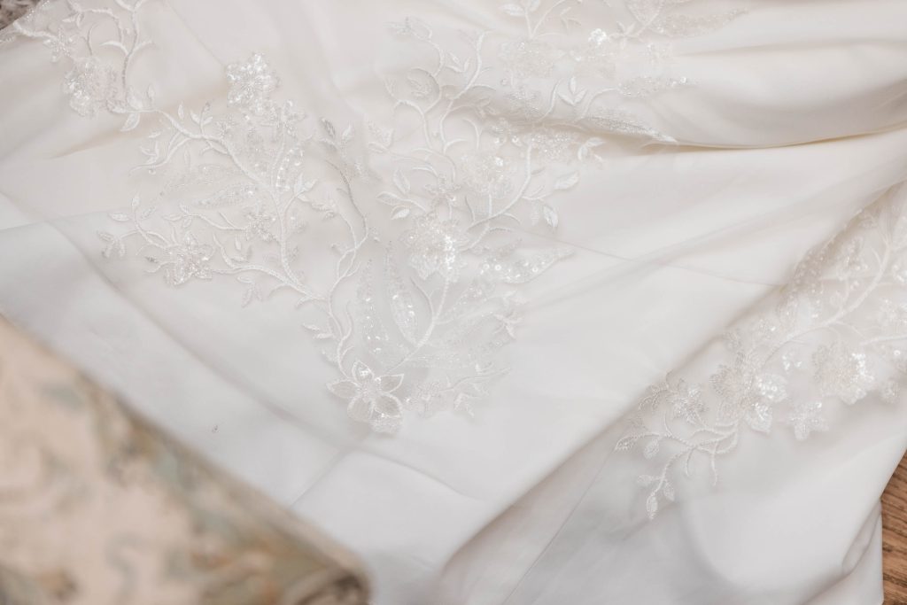 A detailed close up of a white wedding dress.