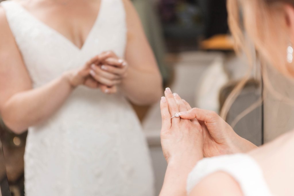 A bride preparing for her wedding by putting on her wedding ring.