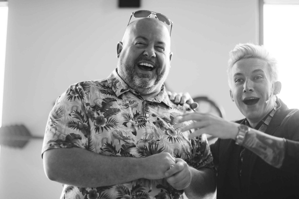 Two men standing next to each other at a birthday party.