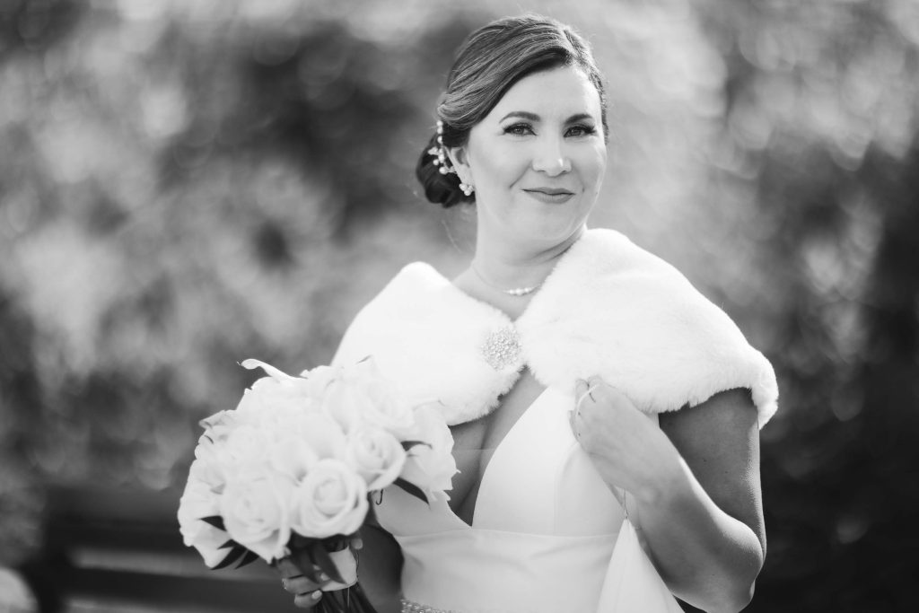 A black and white wedding portrait featuring a bride holding a bouquet.