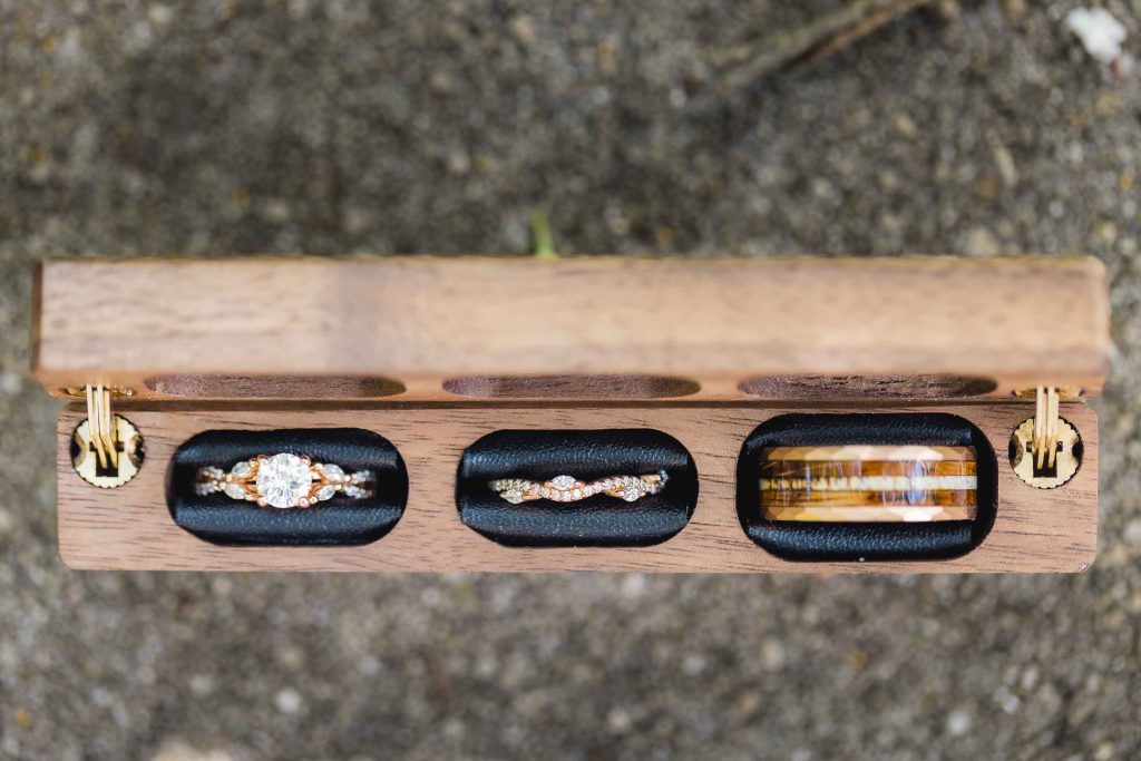 A wooden box with three rings, perfect for wedding details.