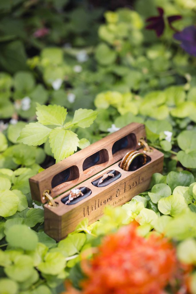 A detailed wooden box containing wedding rings.