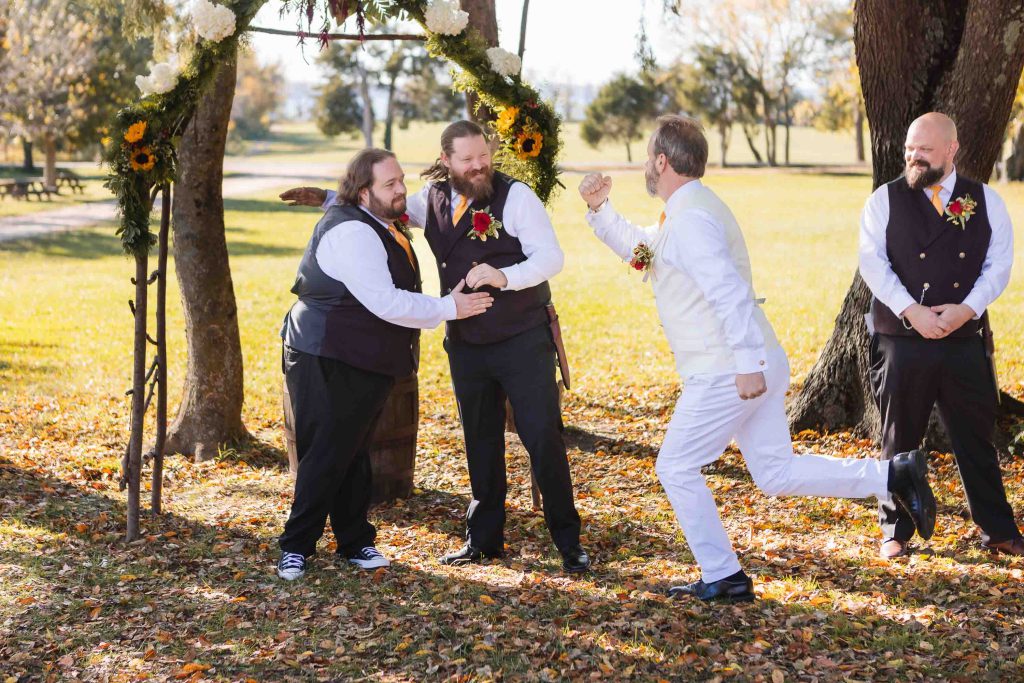A group of groomsmen jumping in the air during a wedding ceremony. (Keywords: Wedding, Ceremony)