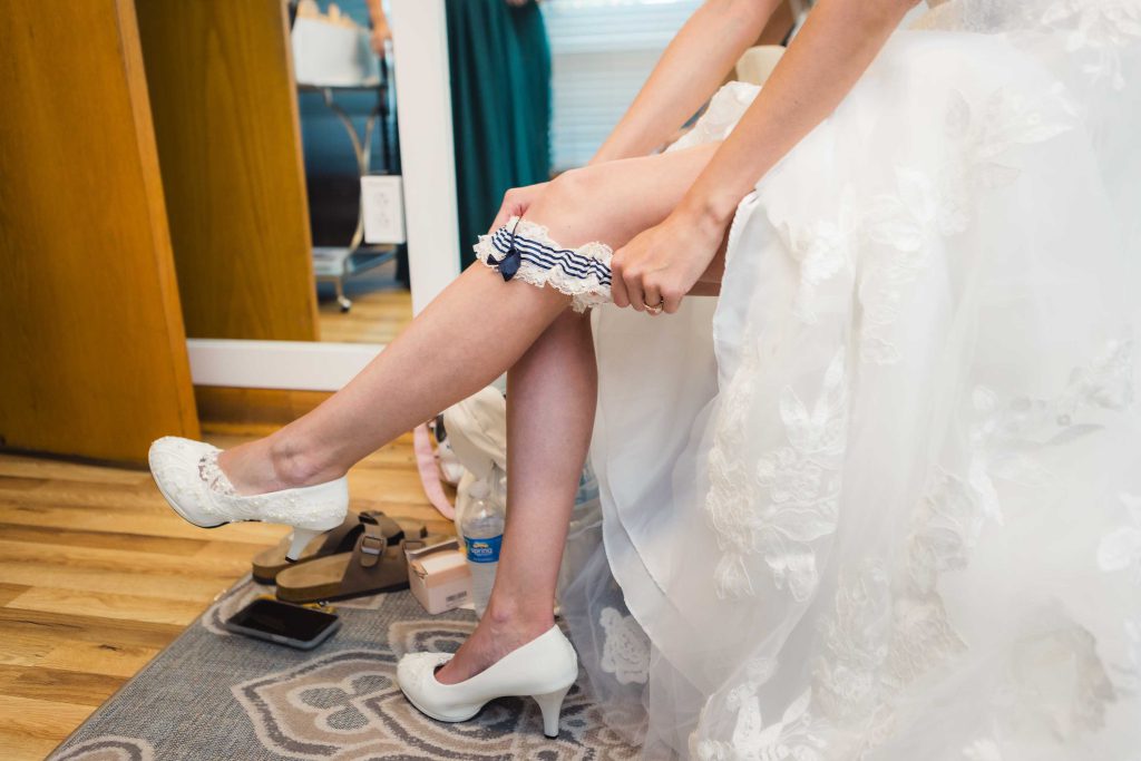 A bride is preparing for her wedding, putting on her shoes.