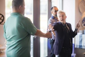 A group of people at a birthday party talking to each other.