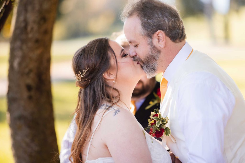 A couple kisses during their wedding ceremony.