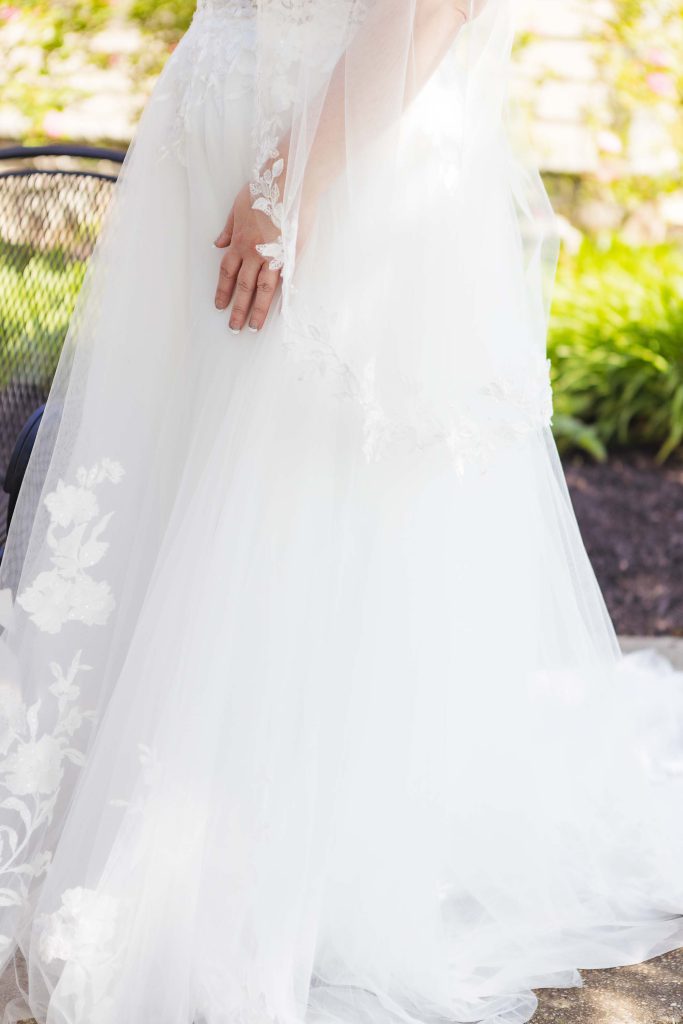 A bride with intricate wedding details, wearing a white dress with a veil.