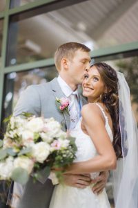 A candid bride and groom kissing during wedding preparation.