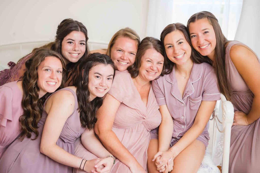 A group of bridesmaids preparing for a candid wedding photo.