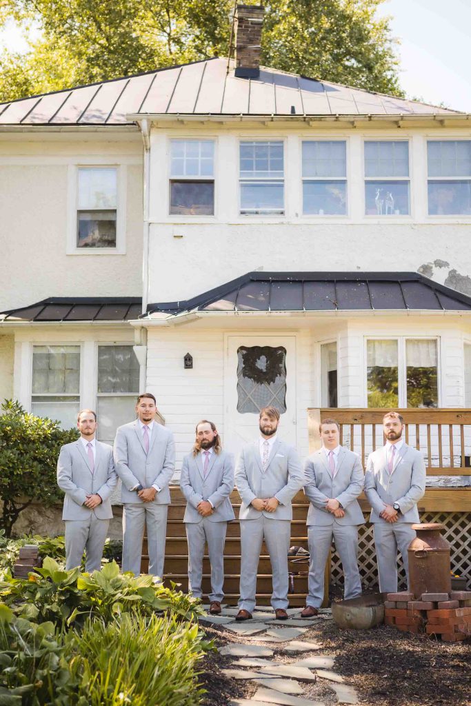 A group of groomsmen posing for a wedding portrait.