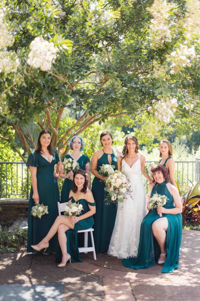 Keywords: Bridesmaids, Photo.

Modified Description: A group of bridesmaids in teal dresses pose for a wedding photo.