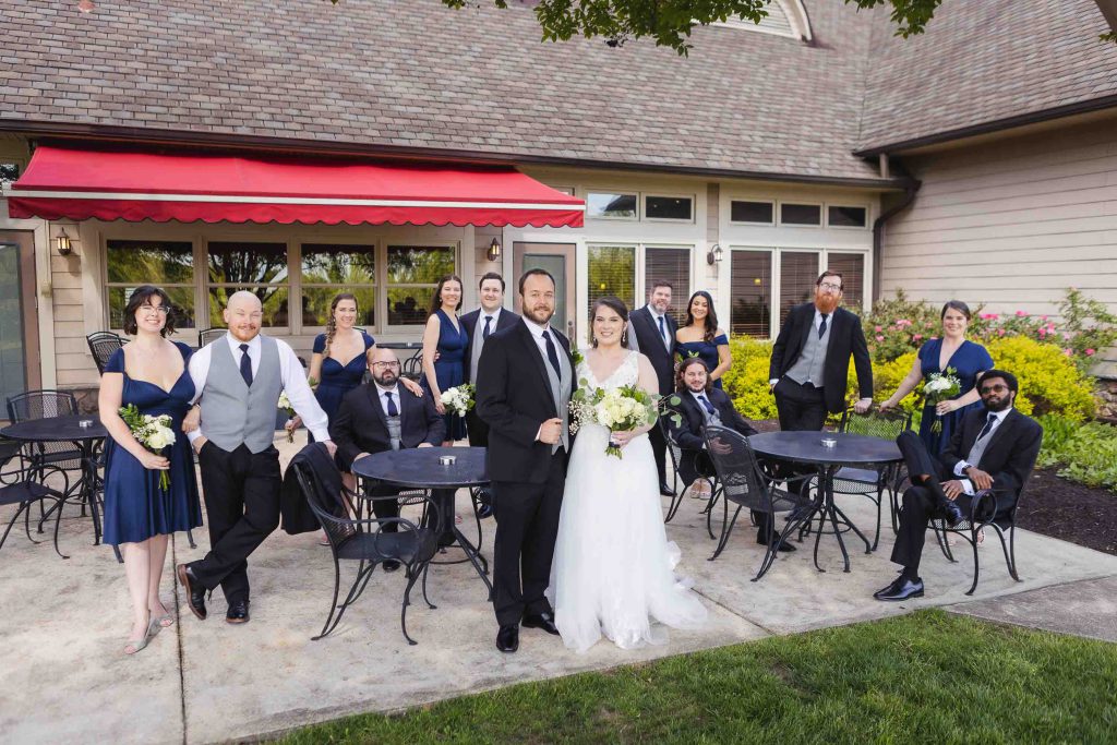 A wedding party posing in front of a restaurant for a portrait.
