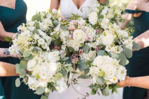 Details of a wedding ceremony with a bride and her bridesmaids holding bouquets.