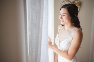 A candid bride in wedding dress during preparation.