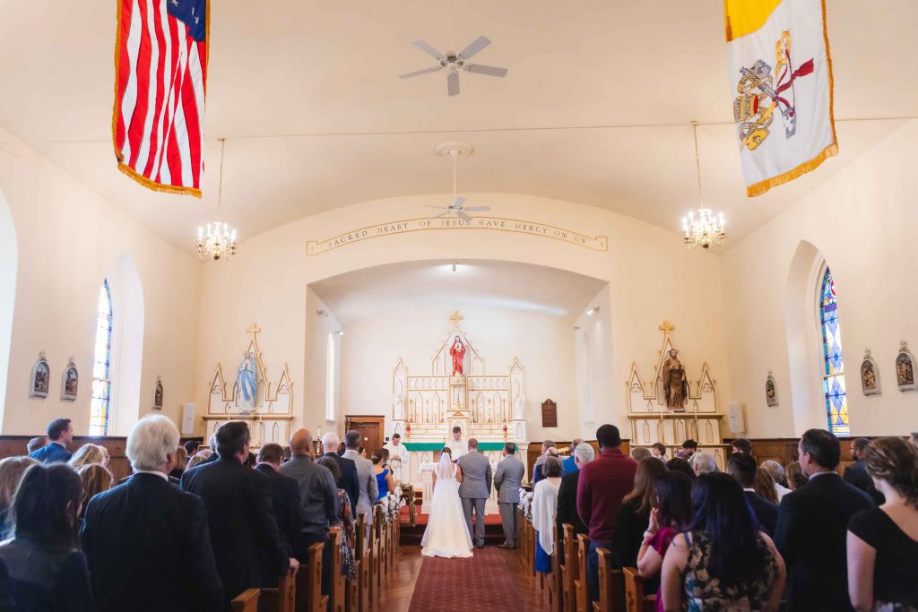 A wedding ceremony with a bride and groom walking down the aisle in a church.