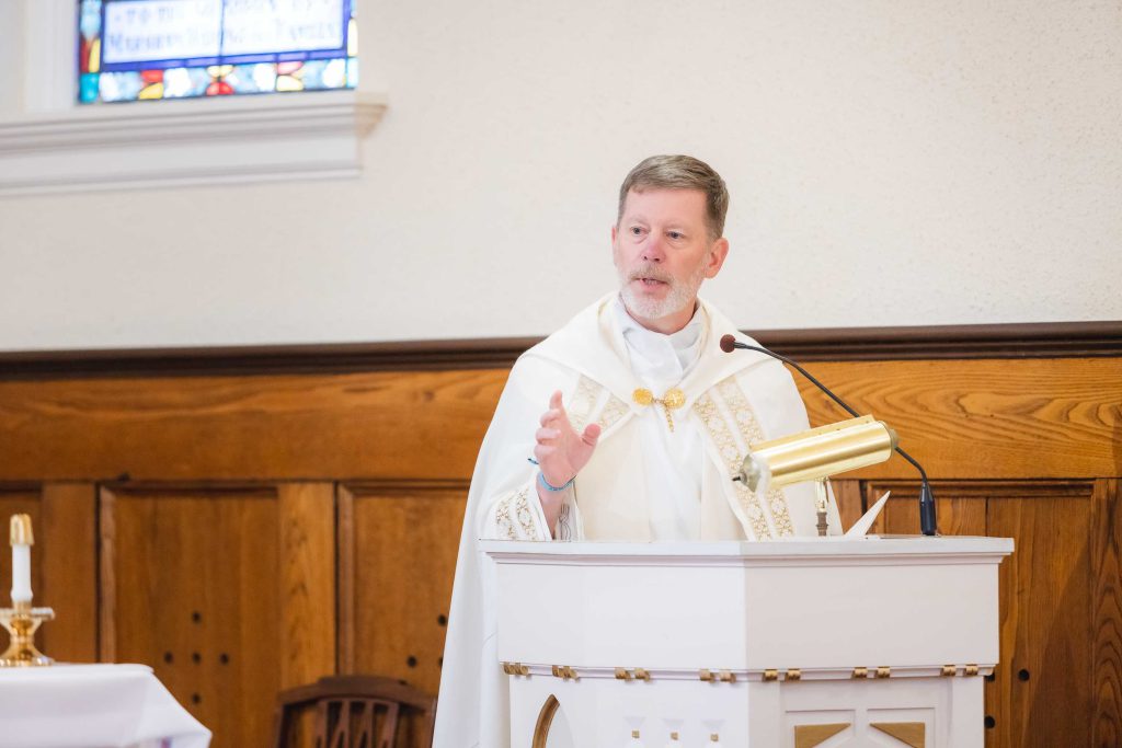 A priest giving a speech at a wedding ceremony.