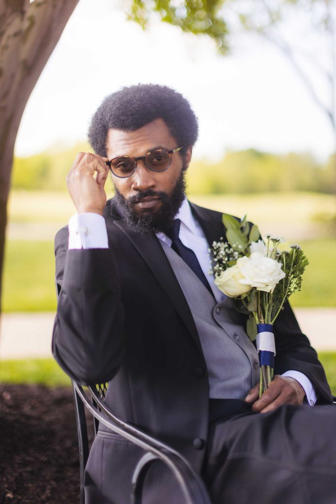 A man in a suit sitting on a bench for a portrait.