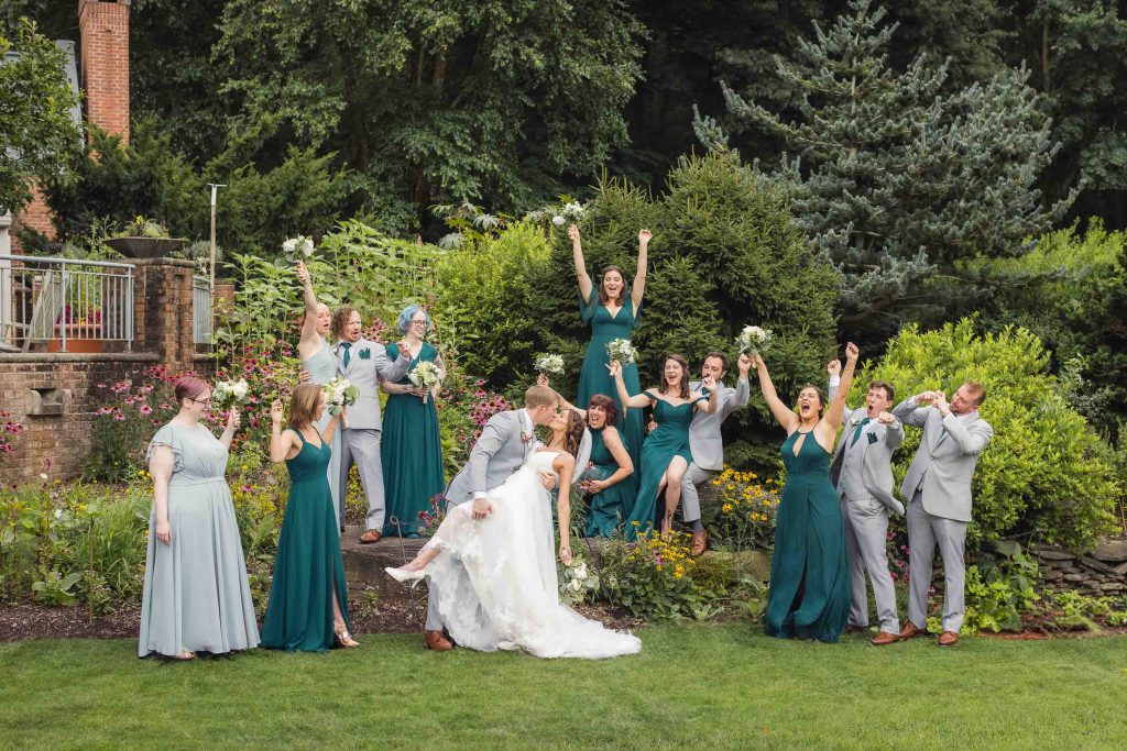 A group of bridesmaids and groomsmen pose for a wedding portrait.