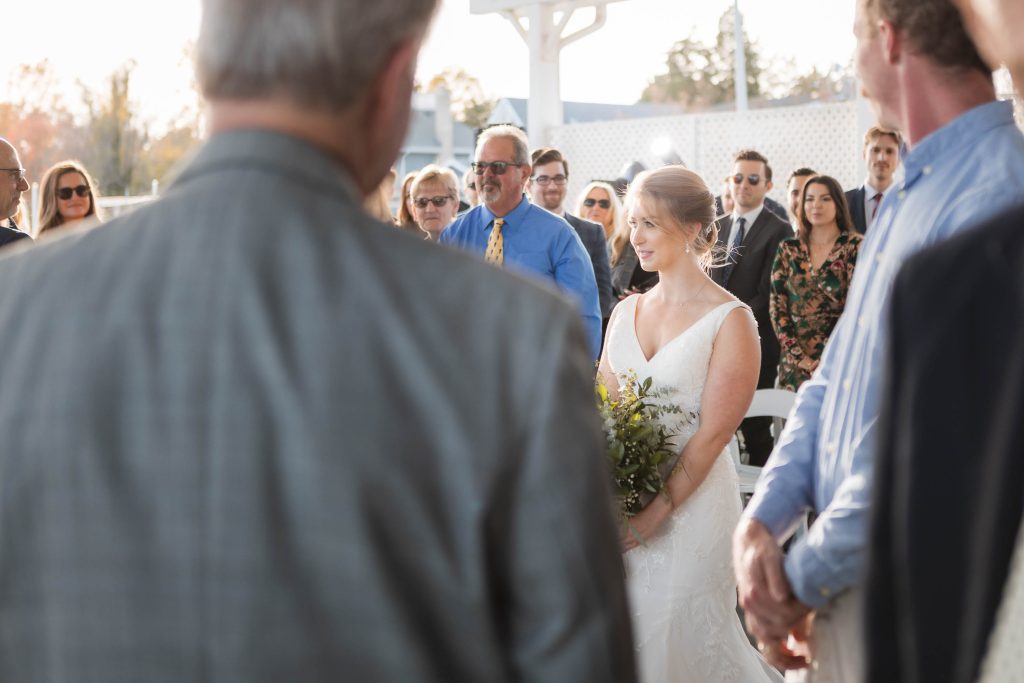 A bride walks down the aisle at a wedding ceremony.