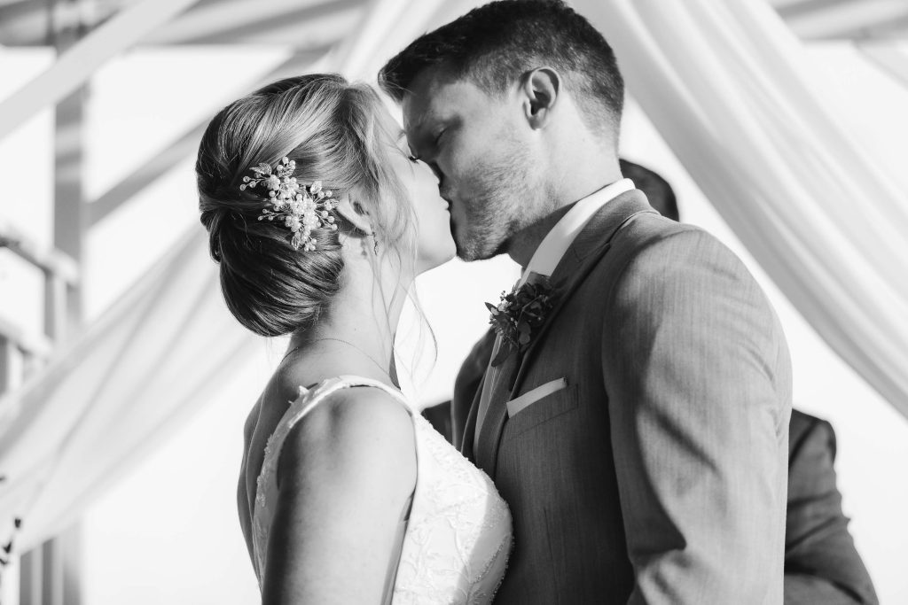 A couple exchanges a kiss at their wedding ceremony.