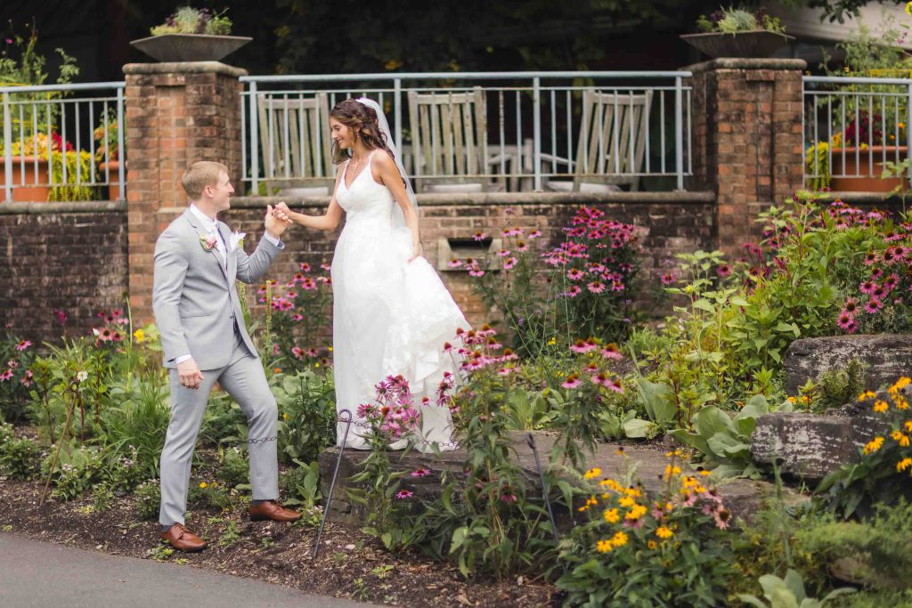 A wedding portrait in front of a flower garden.