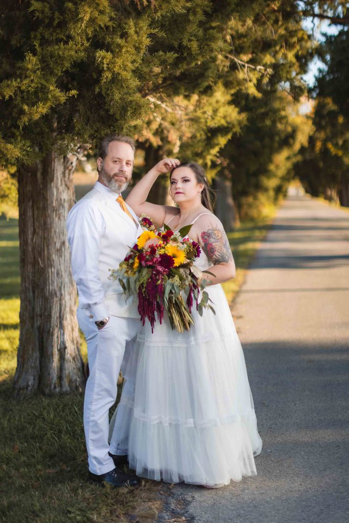 A couple posing in front of a tree during their wedding.