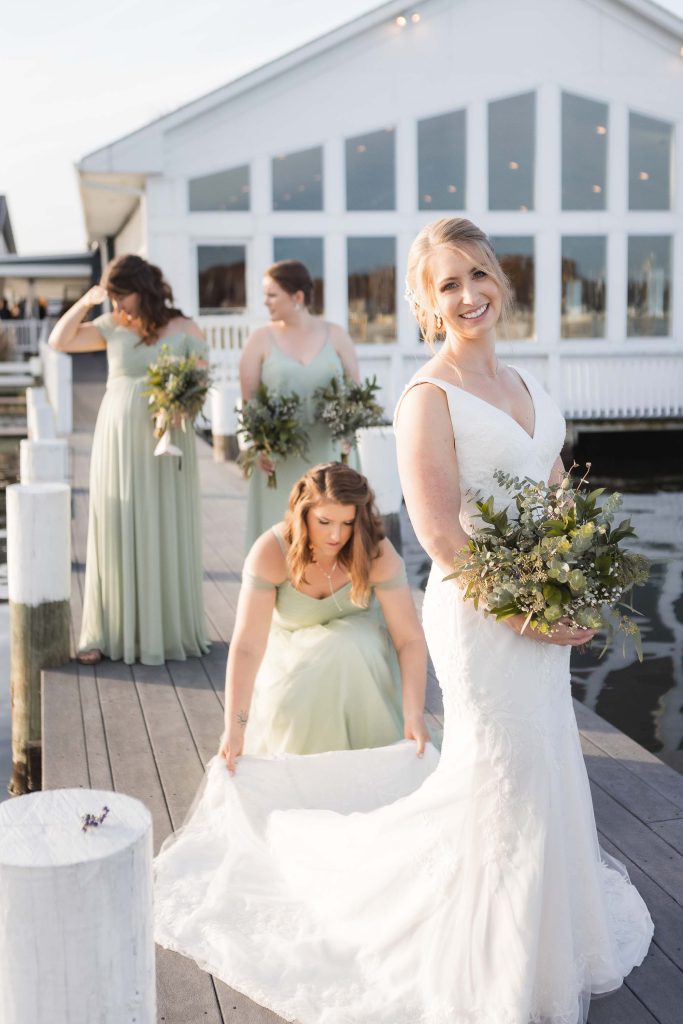A wedding portrait of a bride and her bridesmaids on a dock.