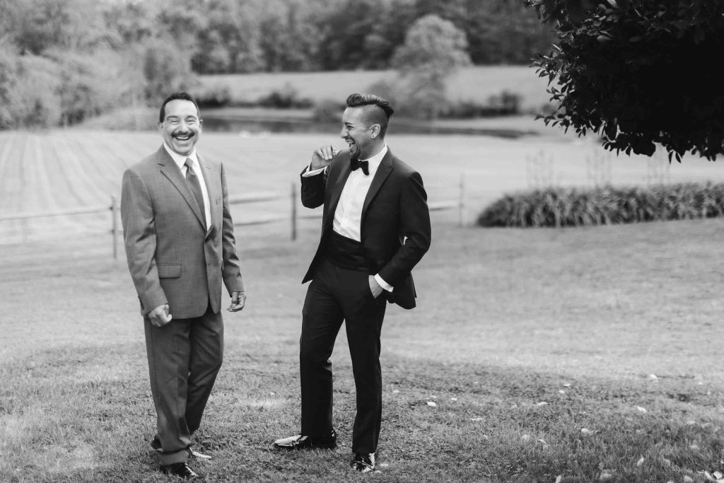 Two men in tuxedos posing for a portrait.