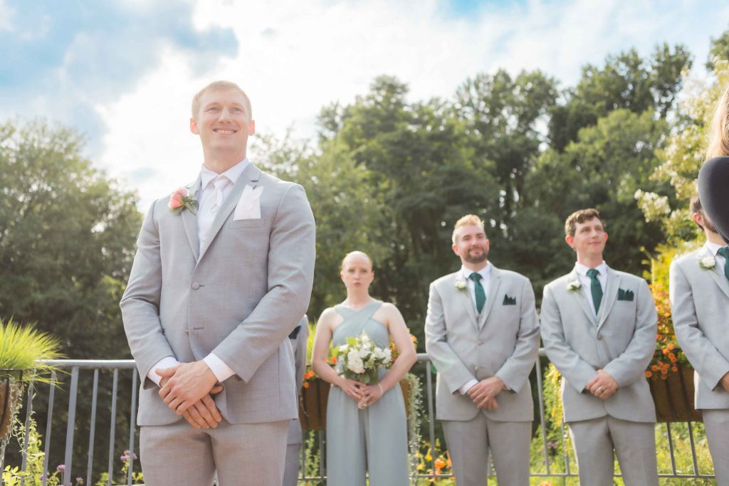 A group of groomsmen standing in front of a wedding ceremony.