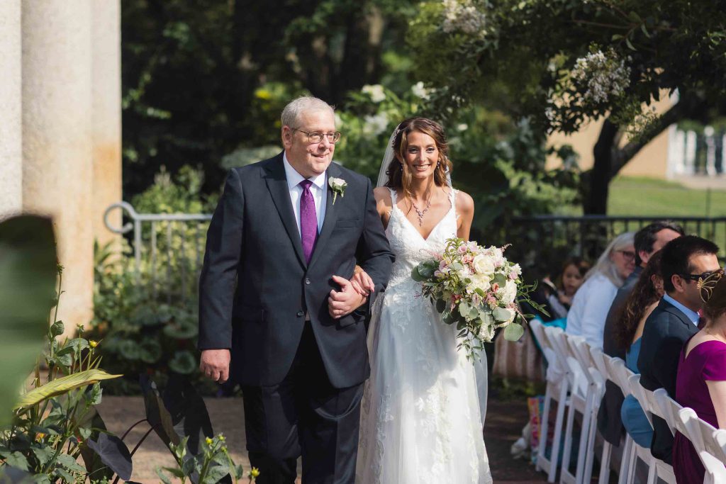 A bride gracefully walks down the aisle during her wedding ceremony.