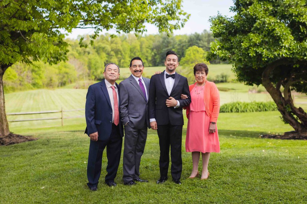 A group of people posing for a wedding portrait in a field.