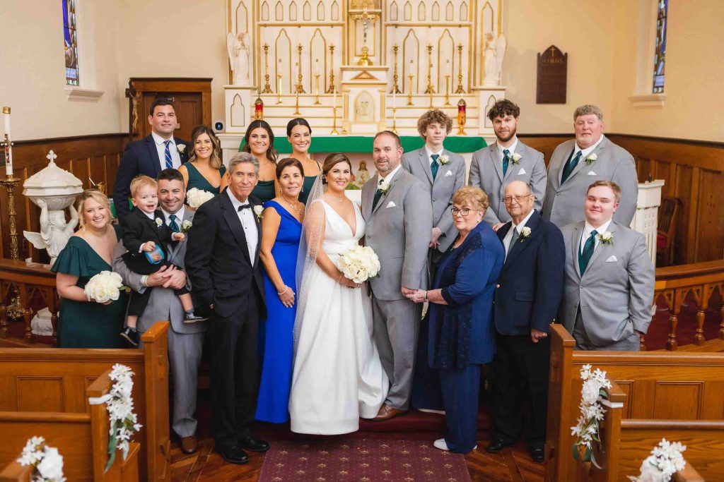 A wedding party posing for a portrait in a church.