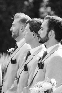 Black and white photo of groomsmen at a wedding ceremony.