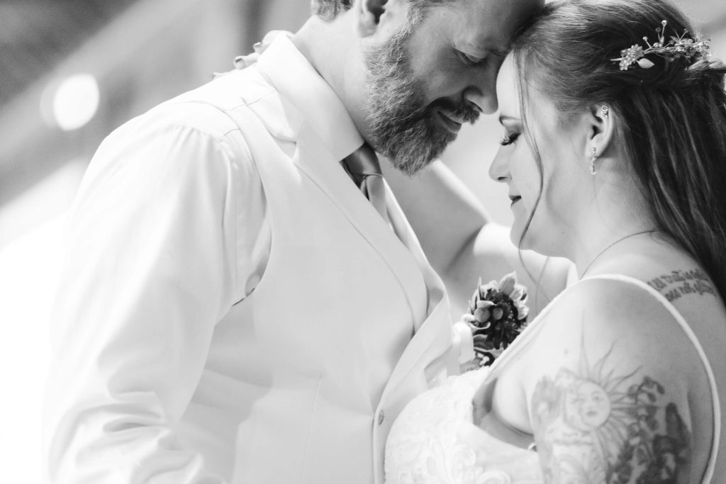 A black and white photo capturing the wedding reception as the bride and groom share their first dance.
