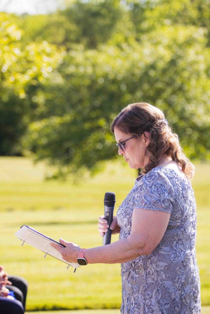 A woman is speaking at a wedding ceremony.
