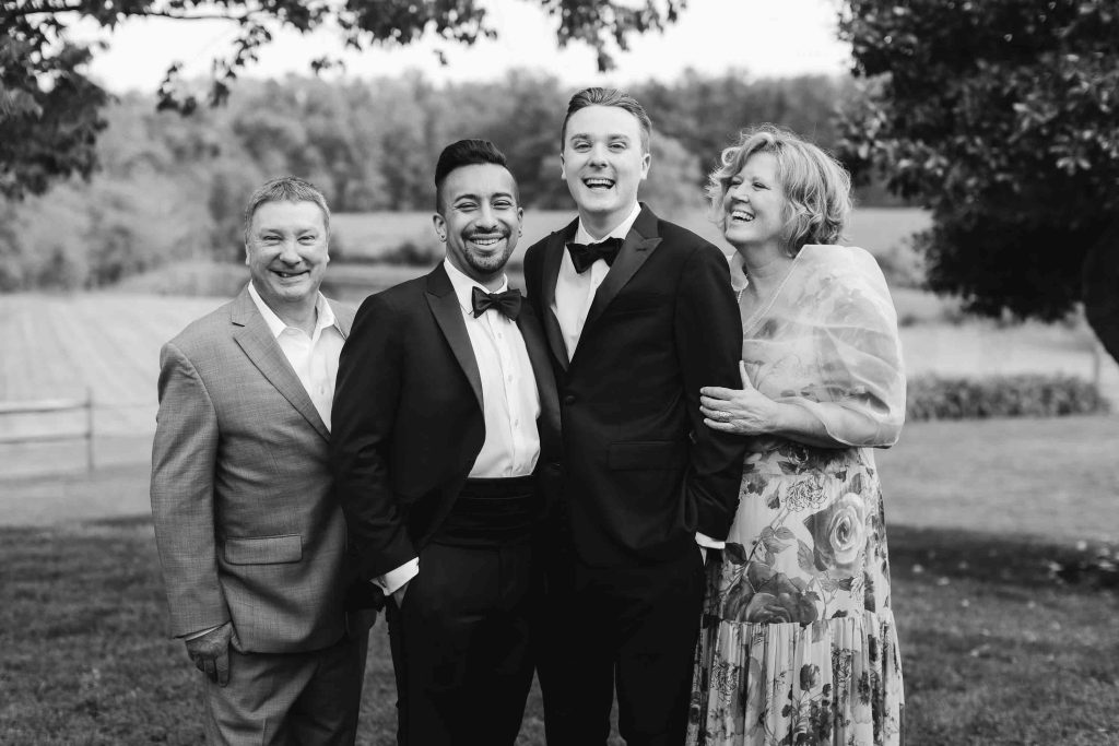 A black and white portrait of a family posing for a wedding photo.