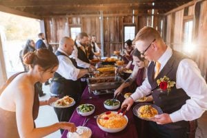 A group serving food at a wedding reception.