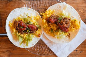 Two wedding taco details on a wooden table.