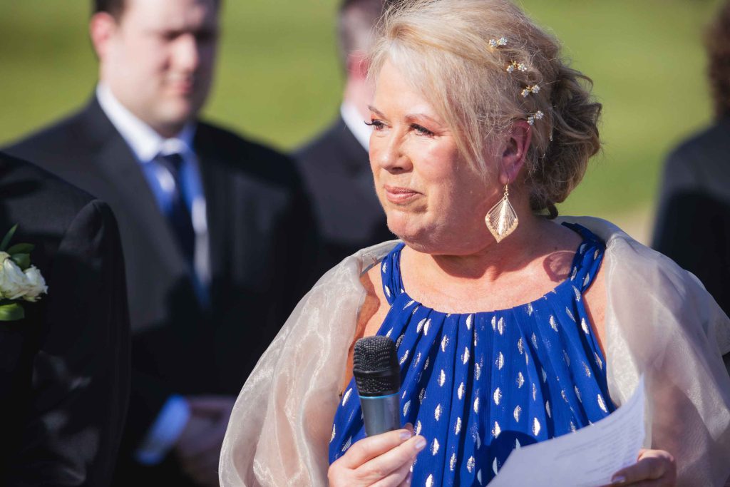 A woman is speaking during a wedding ceremony.