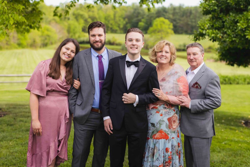 A family posing for a portrait in front of a field.