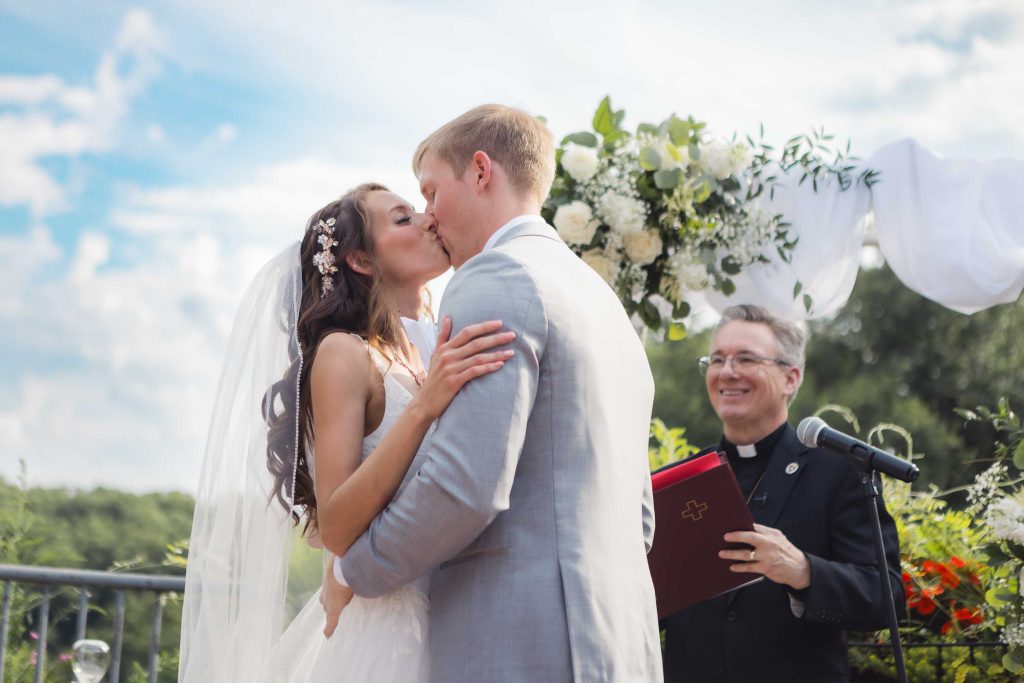 A couple shares a kiss at their wedding ceremony.