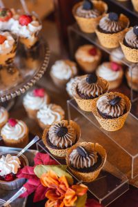 A display of cupcakes and cupcakes on a table at a wedding.