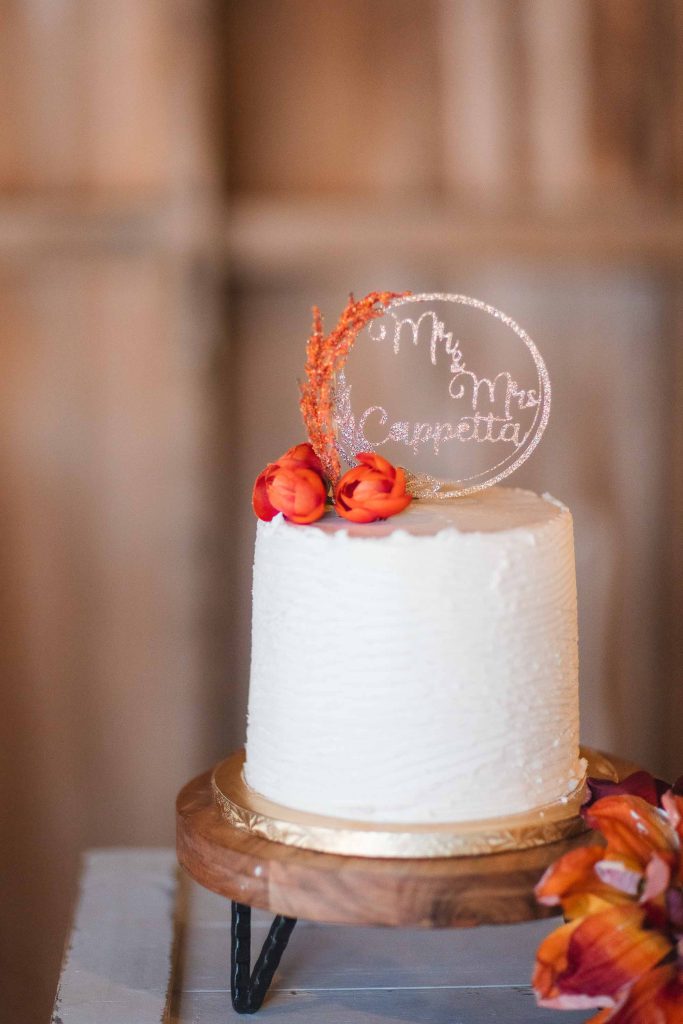 A detailed wedding cake decorated with orange flowers.