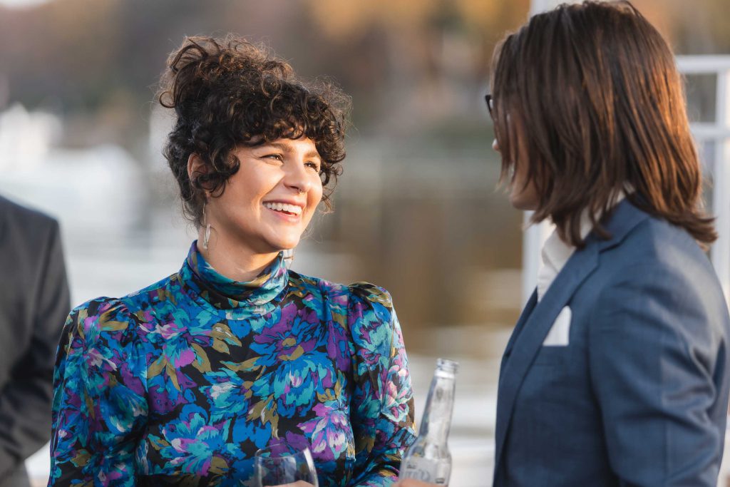 A woman and a man talking on a boat at their wedding reception.