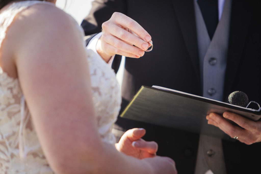 A man is performing a wedding ceremony for a bride.